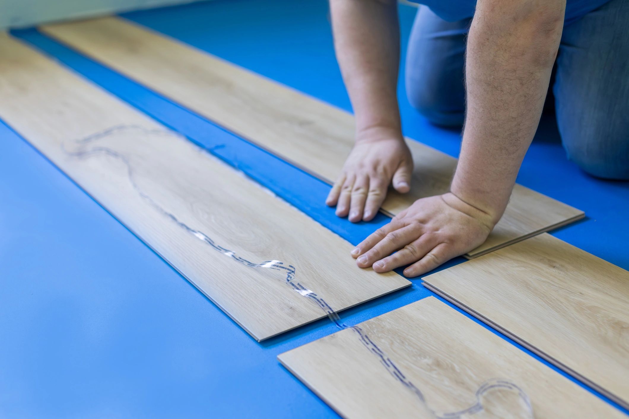 Installer placing underlayment during floor preparation