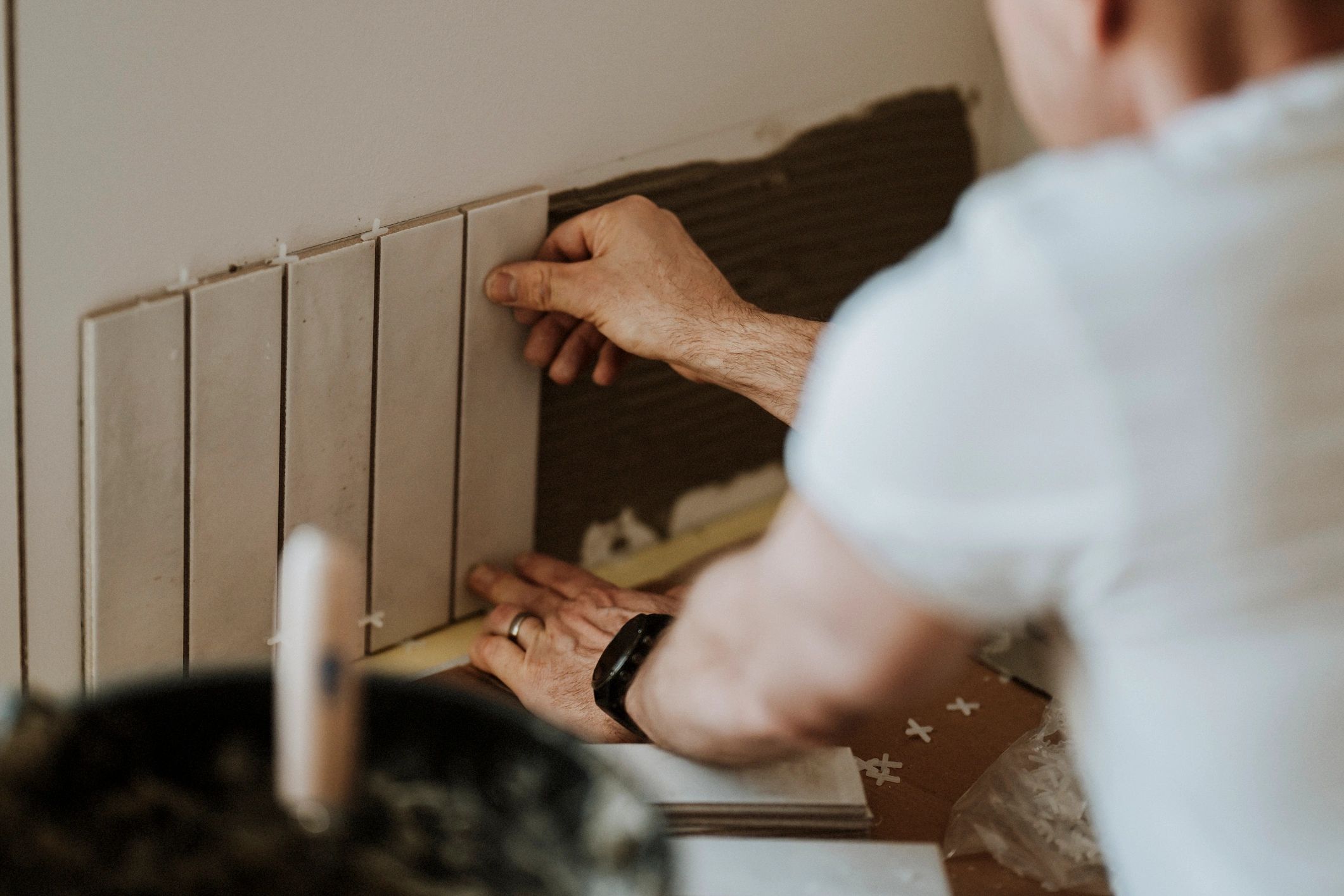Contractor installing tile on a wall with careful alignment
